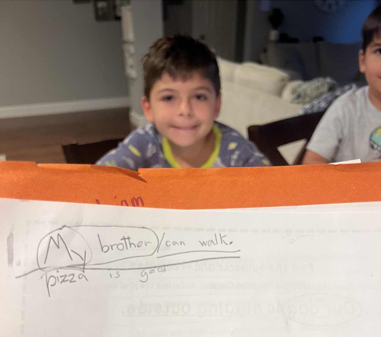 "My brother can walk" written on paper with older brother smiling in background