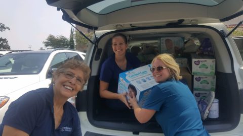 ESGH staff unloads diapers from the back of a minivan for Hurricane Beryl victims.