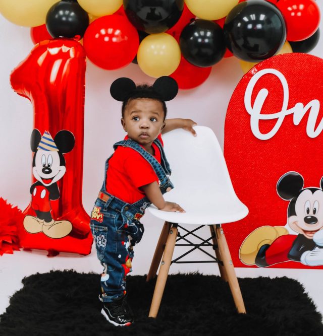 RJ in front of a Mickey Mouse themed balloon arch.